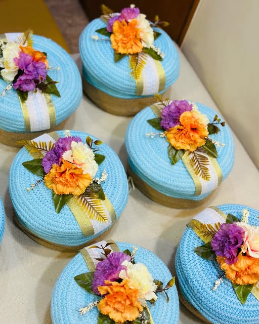 Sky-blue jute gift boxes decorated with vibrant flowers and ribbons by Fruity Florae