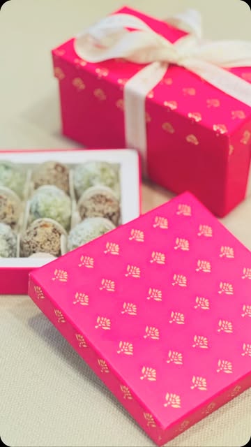 Pink and gold festive gift boxes with ivory ribbons and sweets